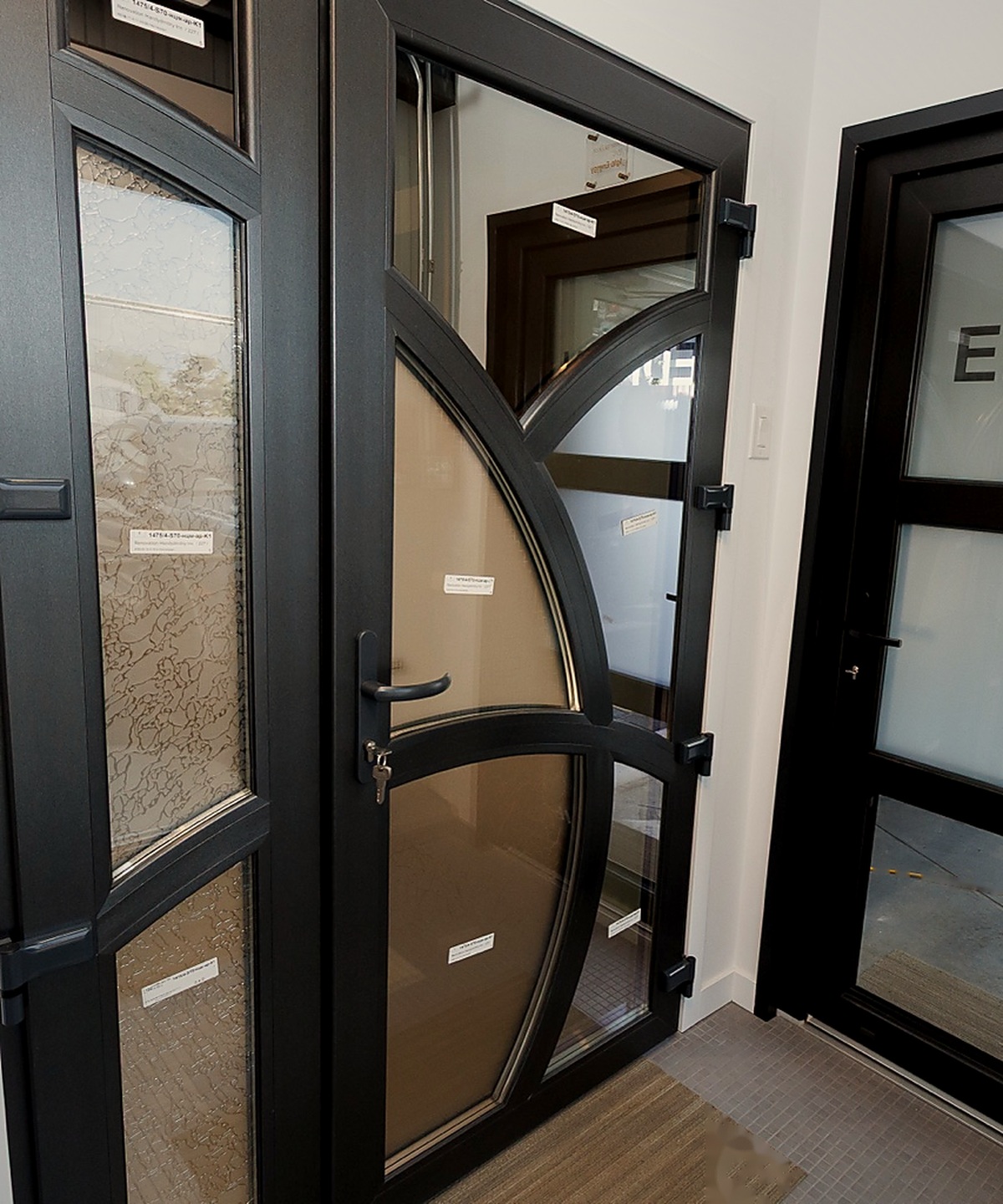 European entry door display with black frames and decorative glass at the EDKAN showroom