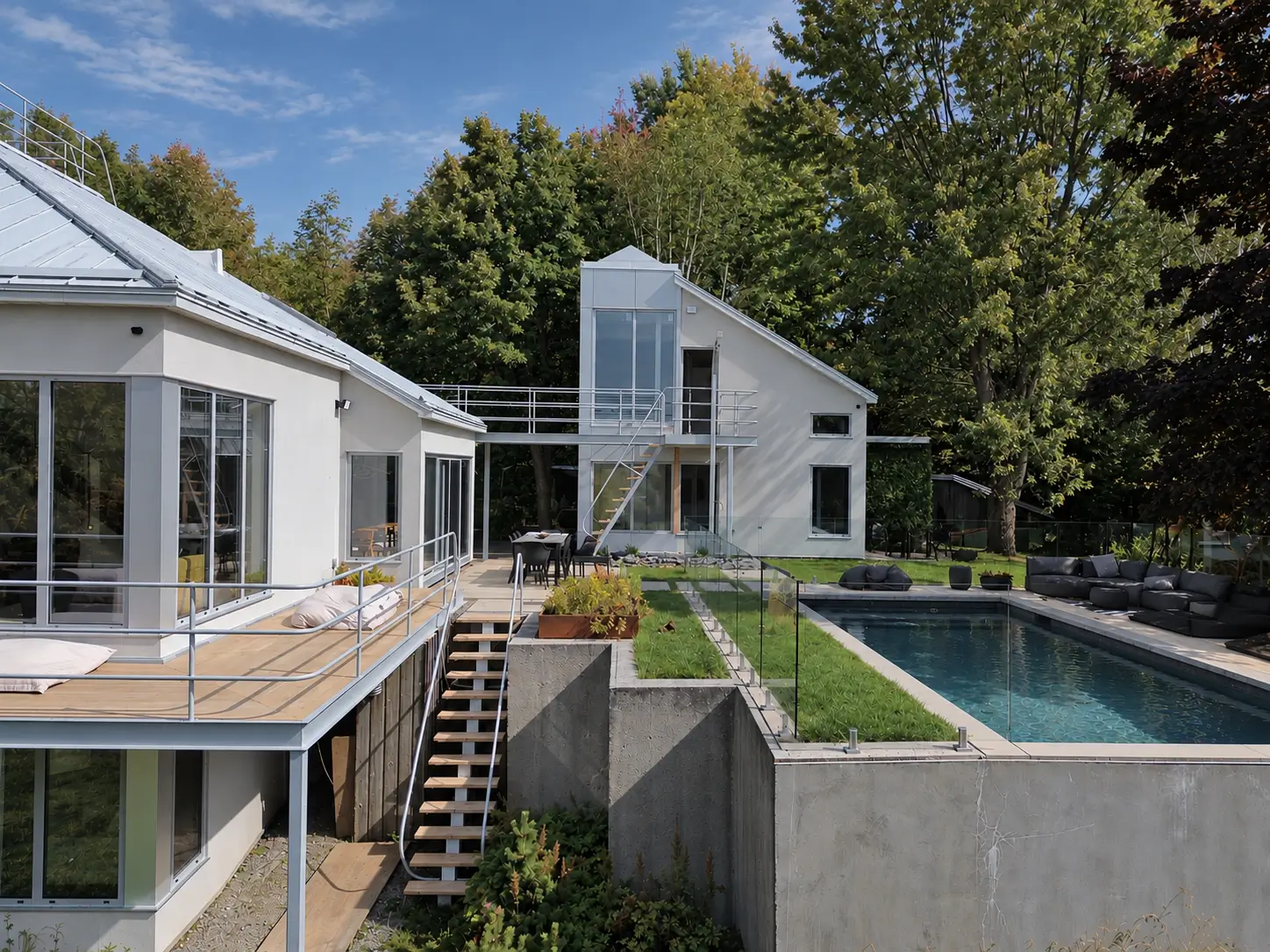 House with corner glazing and a raised deck beside the glazed annex, a concrete retaining wall and a swimming pool with a glass guard