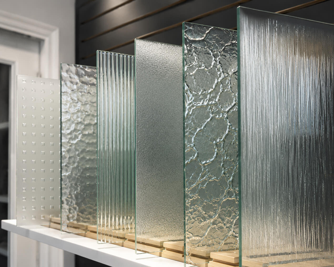 Decorative glass samples with textured privacy glazing displayed in the EDKAN showroom